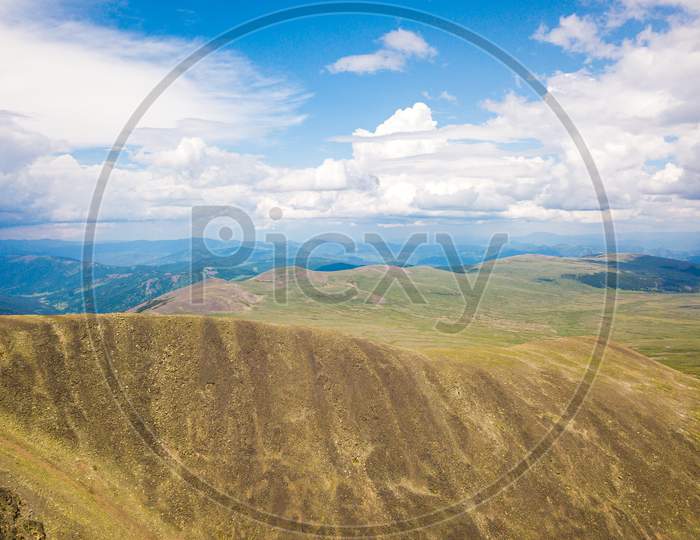 Amazing View On Green Mountains From A Viewpoint. Panorama Of The Mountains  In Altai On A Summer Clear Day. A Landscape View Of Beautiful Fresh Green Field   And  Altai Mountain Background.