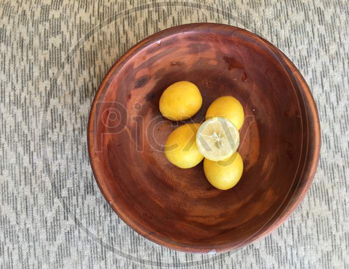 Lemons In A Wooden Bowl And Sliced