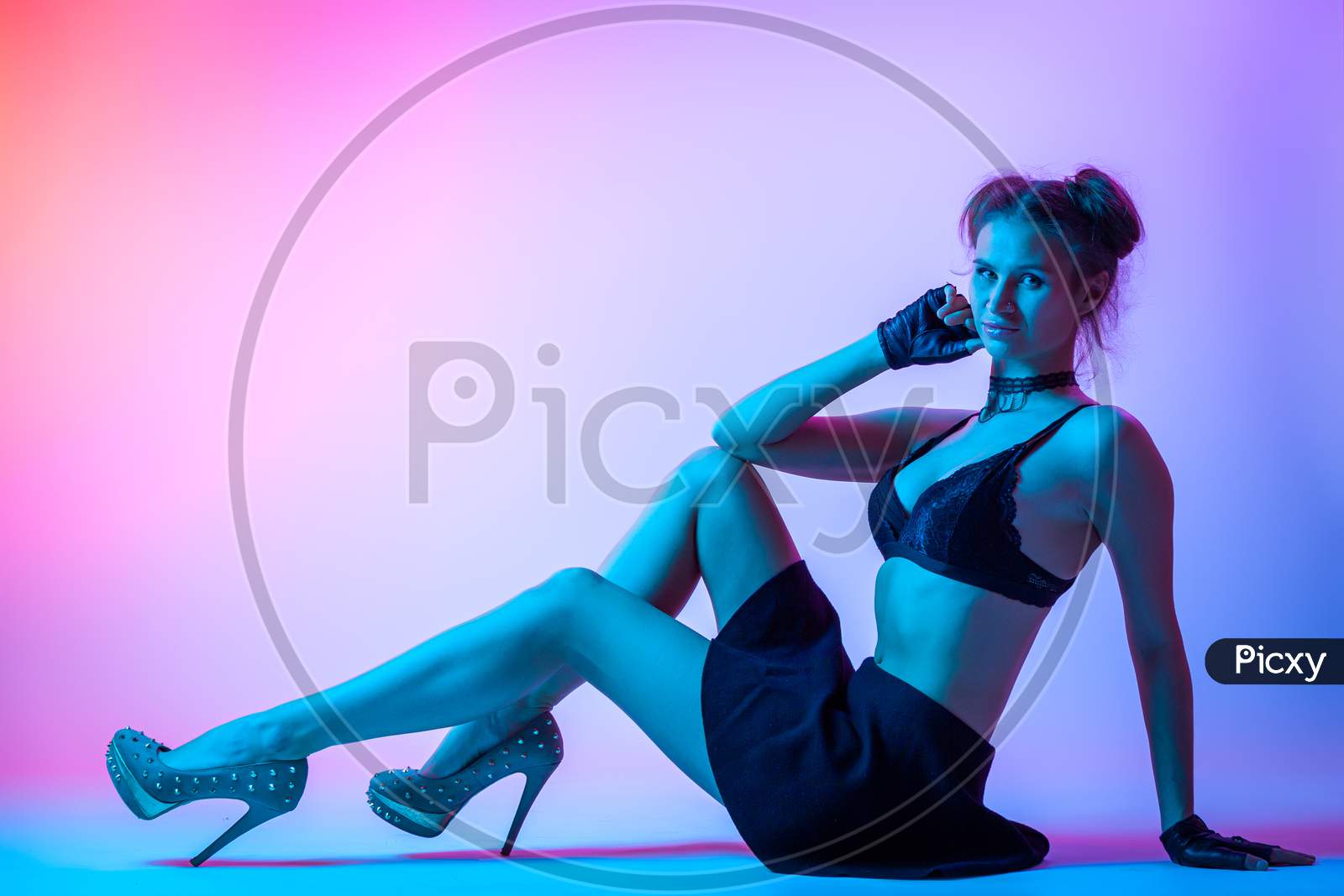 Attractive  Long-Haired Girl, Stylish Fashion. Design Art Concept. Creative Colorful Bright Neon Portrait . Beautiful Girl In Lingerie And Skirt Posing. Cinematic Night Portrait Of Woman In  Neon.