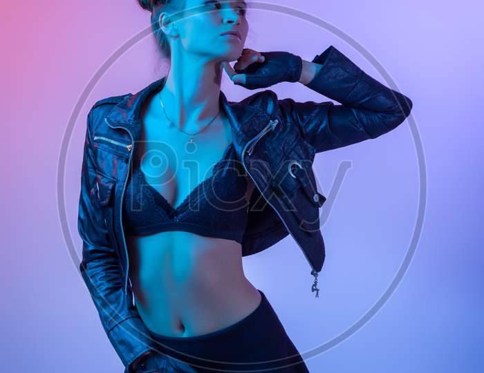 Attractive  Long-Haired Girl, Stylish Fashion. Creative Colorful Neon Portrait . Beautiful Girl A Black Leather Jacket, Underwear And Shirt Posing. Cinematic Night Portrait Of Woman In  Neon.