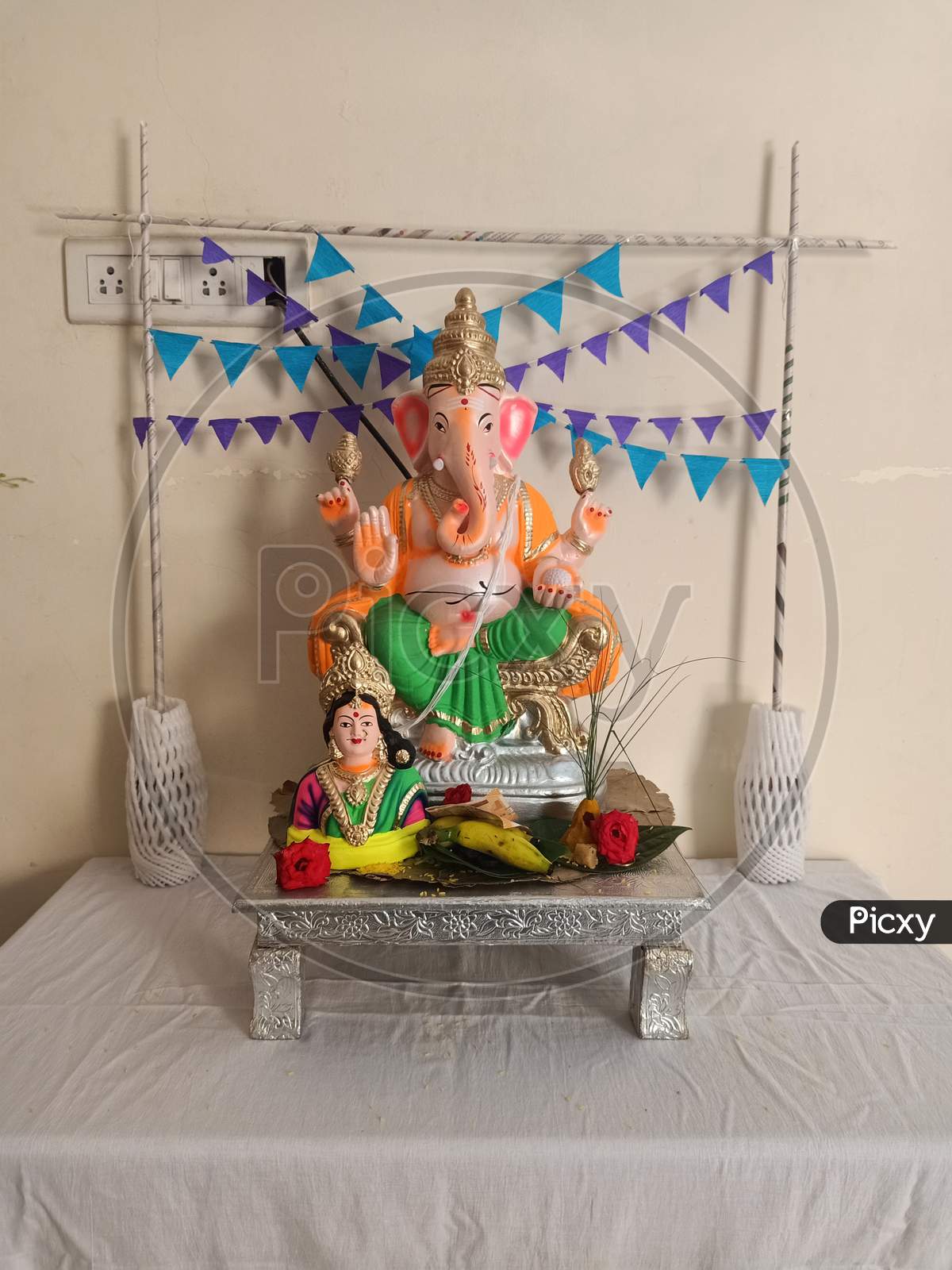 celebrating the Ganesh Chaturthi festival in a home decorated with garland flowers, lamps, fruits... Vinayaka Chaturthi,  Ganapati pooja, and Gowri Habba