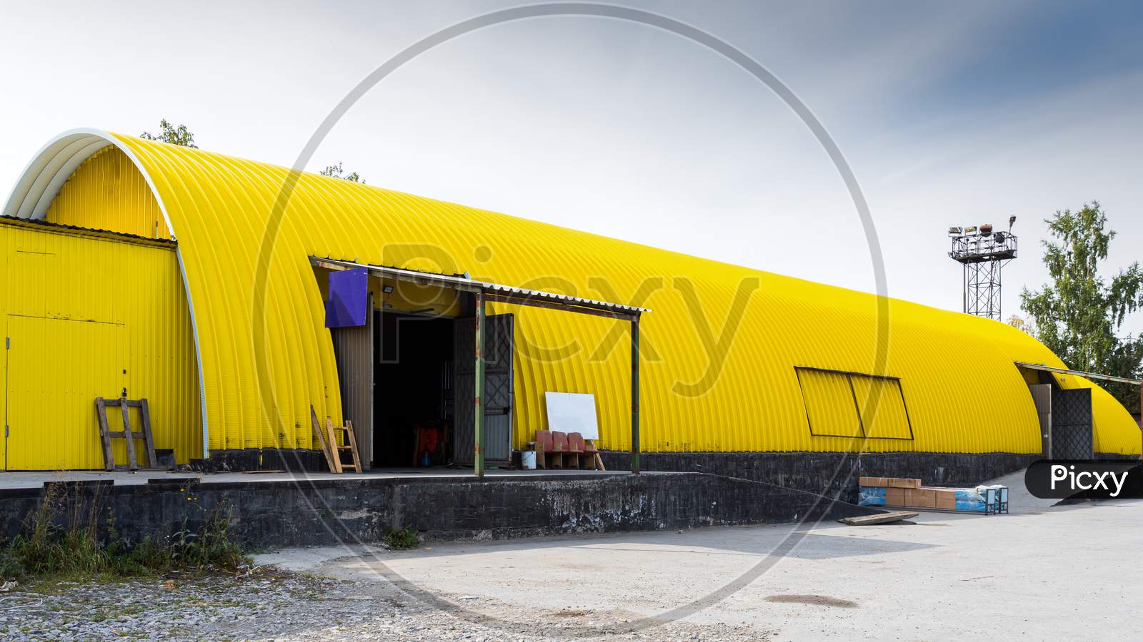Facade Of A Yellow Metal Warehouse, Commercial Building For Storage Of Goods. The Concept Of Storage Of Goods By Importers, Exporters, Wholesalers, Transport Enterprises, Customs