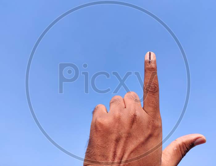 South Indian Man Hands With Voting Sign Or Inked In Forefinger. Cloud Background