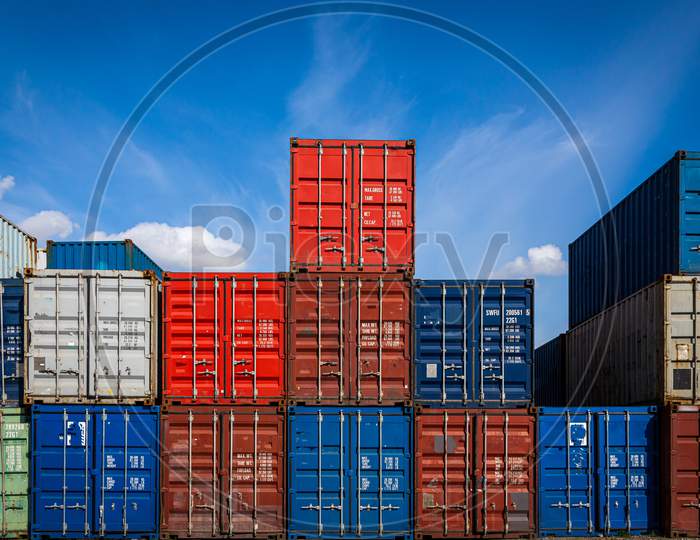 The Territory Of The Container Freight Yard:A Lot Of Metal Containers For Storing Goods Of Different Colors, Stacked In Rows On Top Of Each Other.Conception Of Storage Of Goods By Importers, Exporters