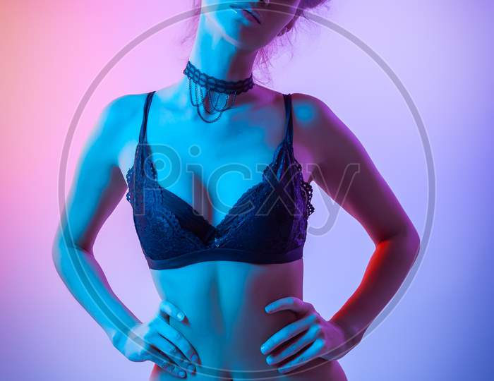 Cinematic Night Portrait Of Woman In  Neon. High Fashion Model Girl In Colorful Bright Neon Lights Posing In Studio, Portrait Of Beautiful Woman In Lingerie And Pants