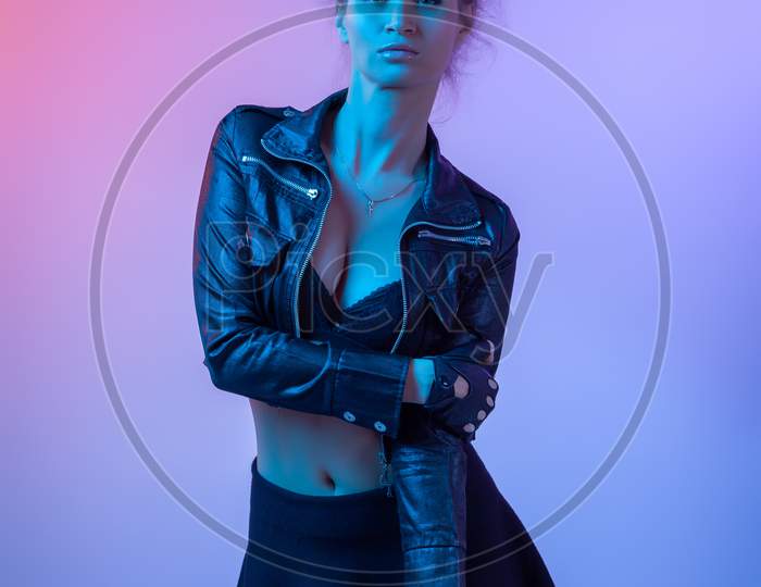 Attractive  Long-Haired Girl, Stylish Fashion. Creative Colorful Neon Portrait . Beautiful Girl A Black Leather Jacket, Underwear And Shirt Posing. Cinematic Night Portrait Of Woman In  Neon.