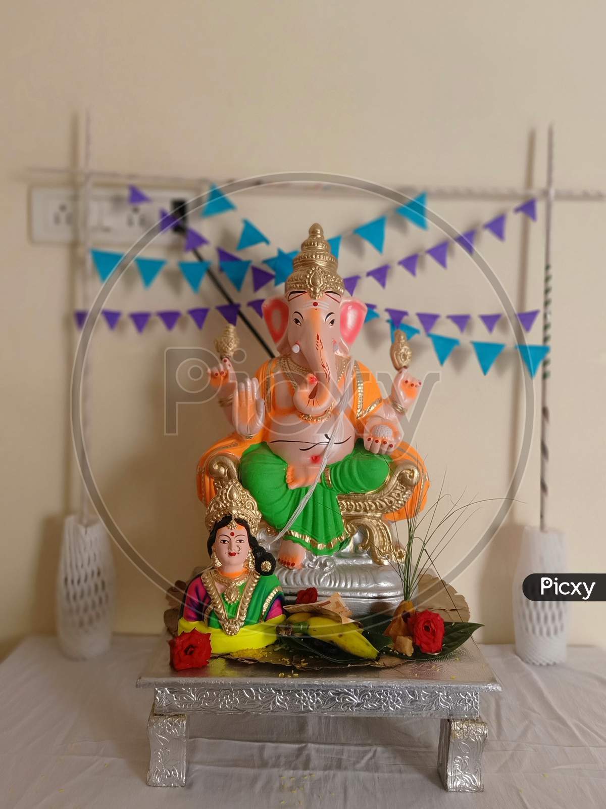 celebrating the Ganesh Chaturthi festival in a home decorated with garland flowers, lamps, fruits... Vinayaka Chaturthi,  Ganapati pooja, and Gowri Habba