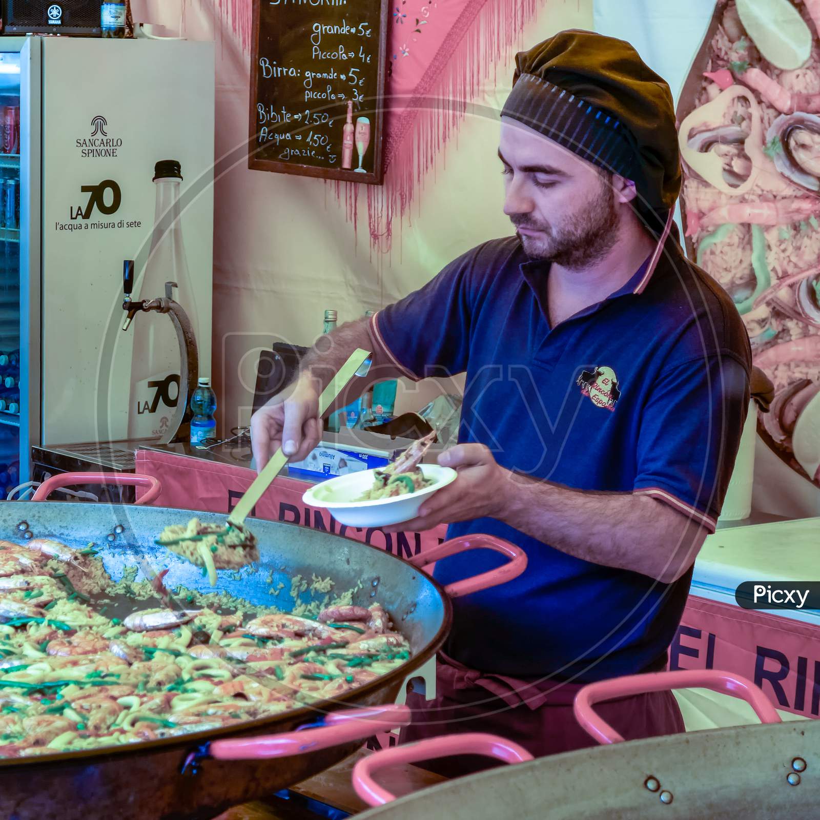 Man Selling Paella On A Market Stall In Bergamo