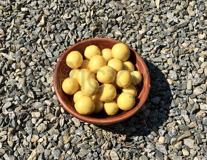 Lemons In A Wooden Bowl Top View With Gravels Background