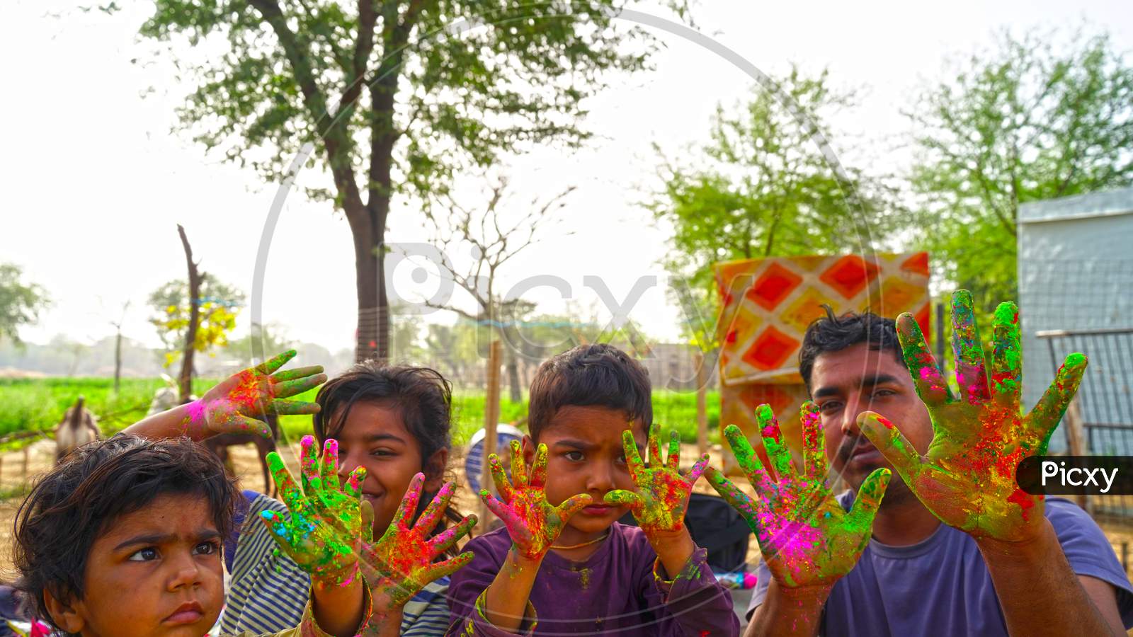 Indian Young Boy Showing Colourful Palm And Celebrating Holi With Colour Splash. Happy Holi Concept 2021.