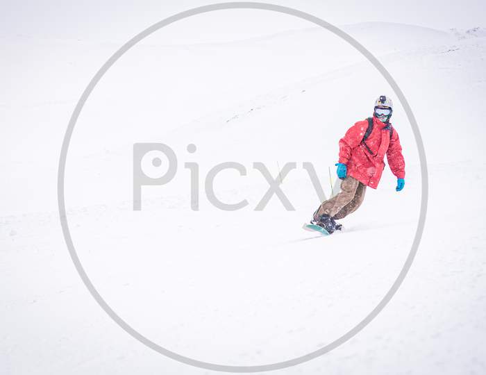 Front Side View Male Person Isolated Snowboarding Downhill In Snowy Conditions. Filming Action Camera Winter Adventures Concept.