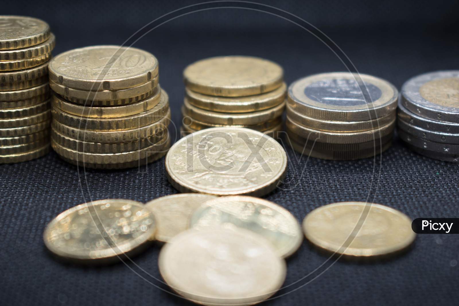 Euro Coins Stacks On Black Background In Different Positions.Euro Coins Stacked In Different Combinations
