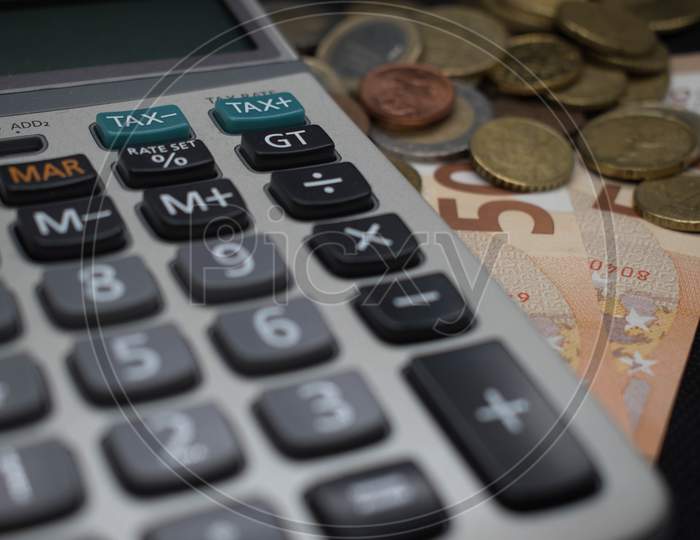 Close Up Of Calculator Near Tax Sign And Euro Currency, Coins, Banknotes.