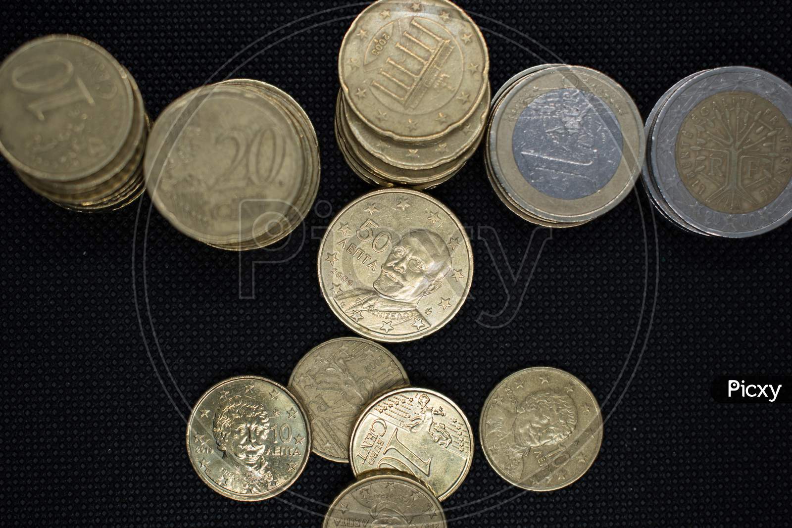 Euro Coins Stacks On Black Background In Different Positions.Euro Coins Stacked In Different Combinations.