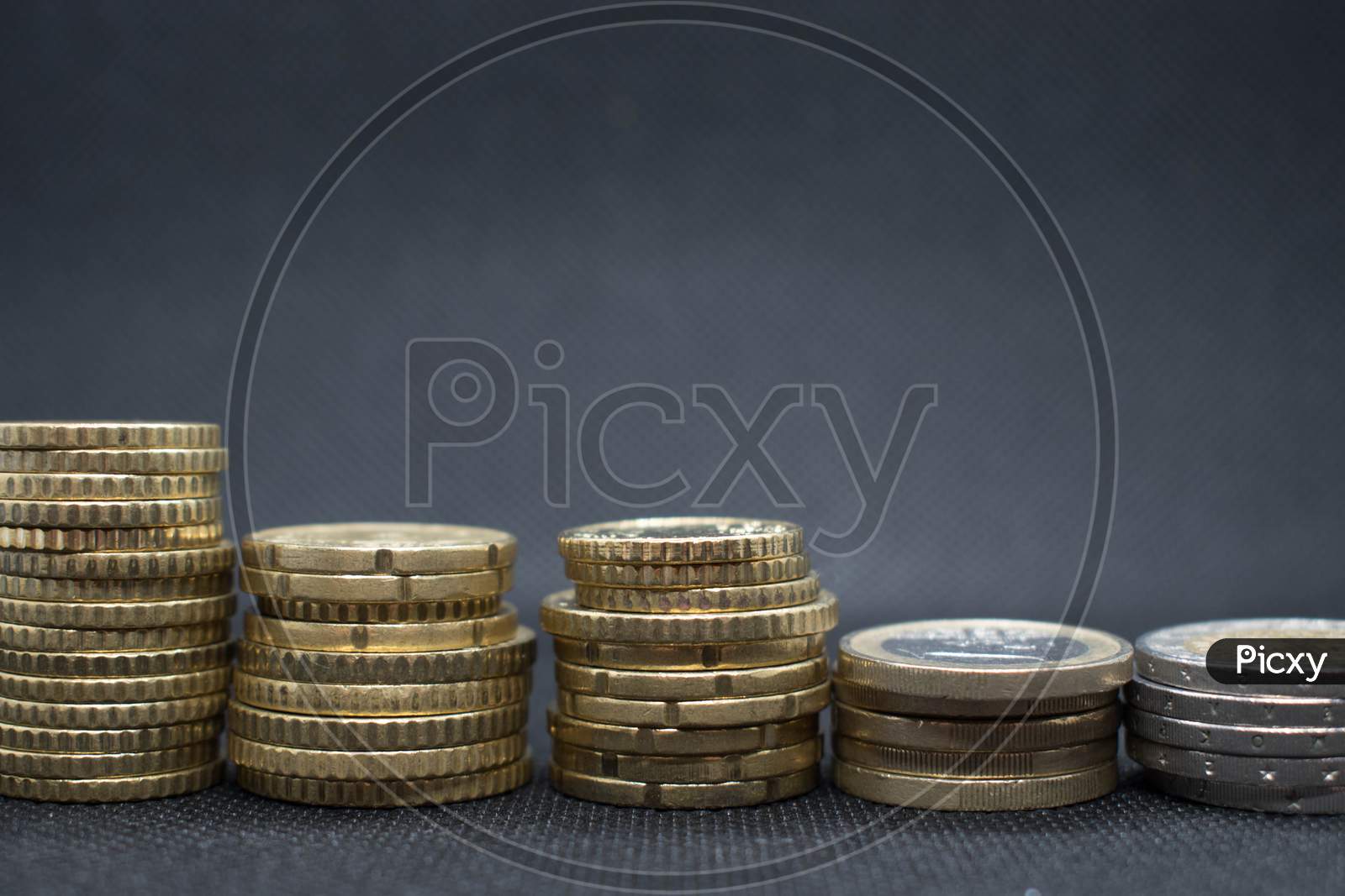 Euro Coins Stacks On Black Background In Different Positions.Euro Coins Stacked In Different Combinations