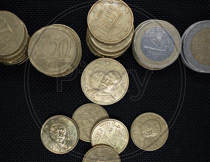 Euro Coins Stacks On Black Background In Different Positions.Euro Coins Stacked In Different Combinations.