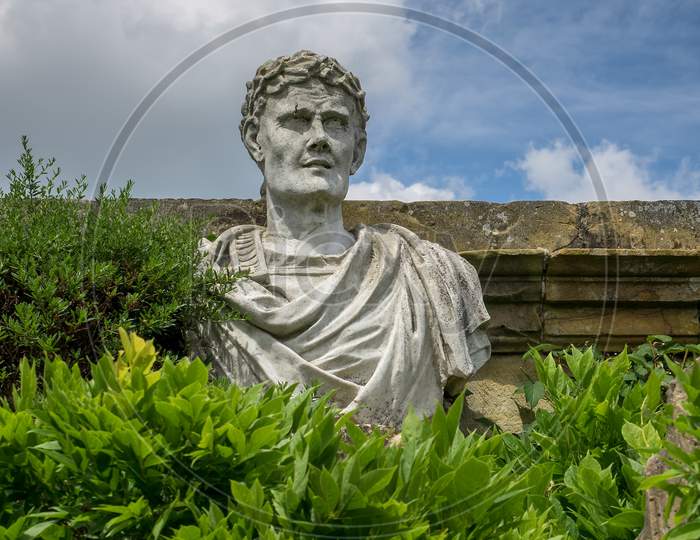 Old Statue Of A Roman In The Garden At Hever Castle