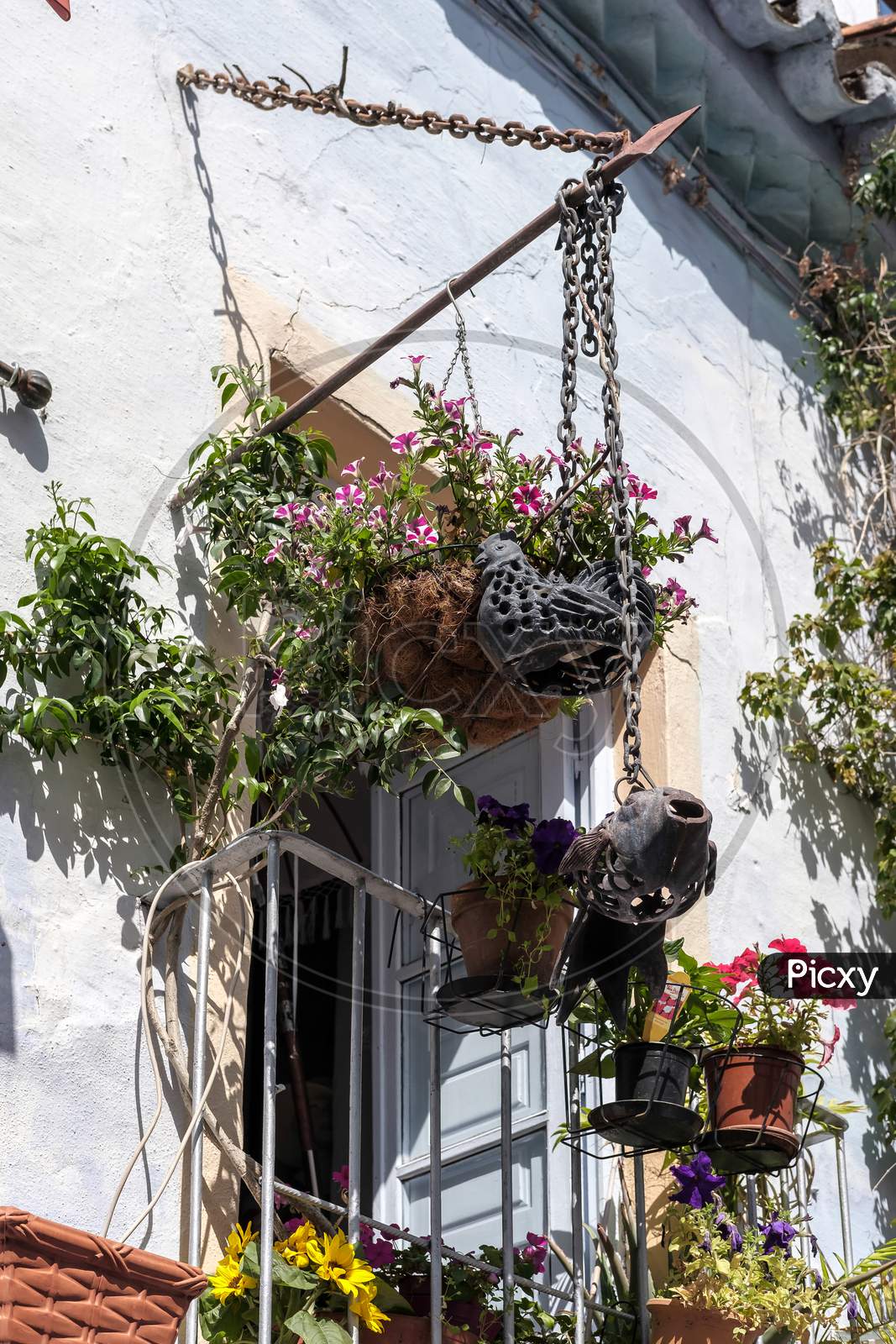 Flowerpots Hanging From A Balcony In The Old Town Of Marbella