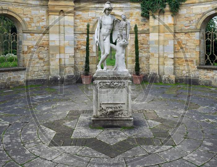 Old Statue Of A Young Man And Eagle In The Garden At Hever Castle