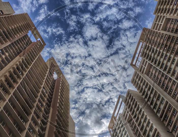 Samta Nagar, Kandivali, Mumbai, Maharashtra / India - Jun 23, 2019: A photo of identical tall parallel buildings in up angle with amazing view of cloudy sky in the background