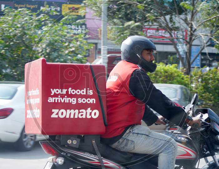 Zomato Delivery Boy With Red Hot Box For Food On A Bike Zooming At High Speed To Deliver Orders For The Upcoming Foodtech Startup From India Which Has Gained A Lot During The Covid Coronavirus Pandemic