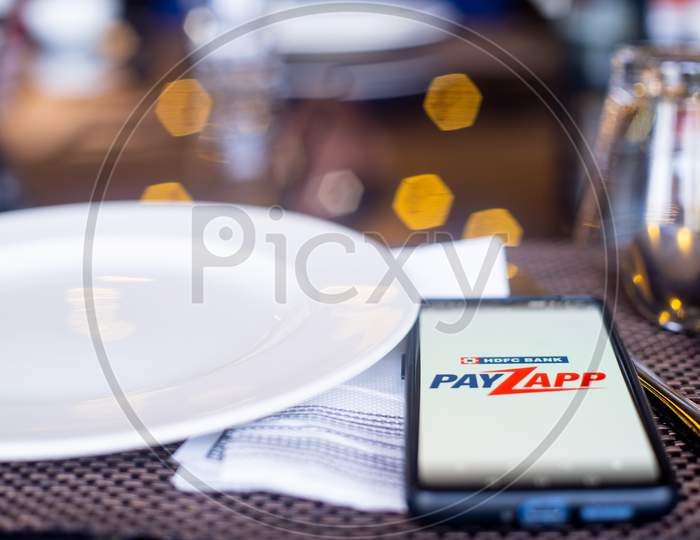 Blue Cloth Mask With Mobile Phone At Side With A Payzapp Logo In Restaurant Showing The Popularity Fo Safe Eating Out And Ordering In As Coronavirus Cases Increase In India