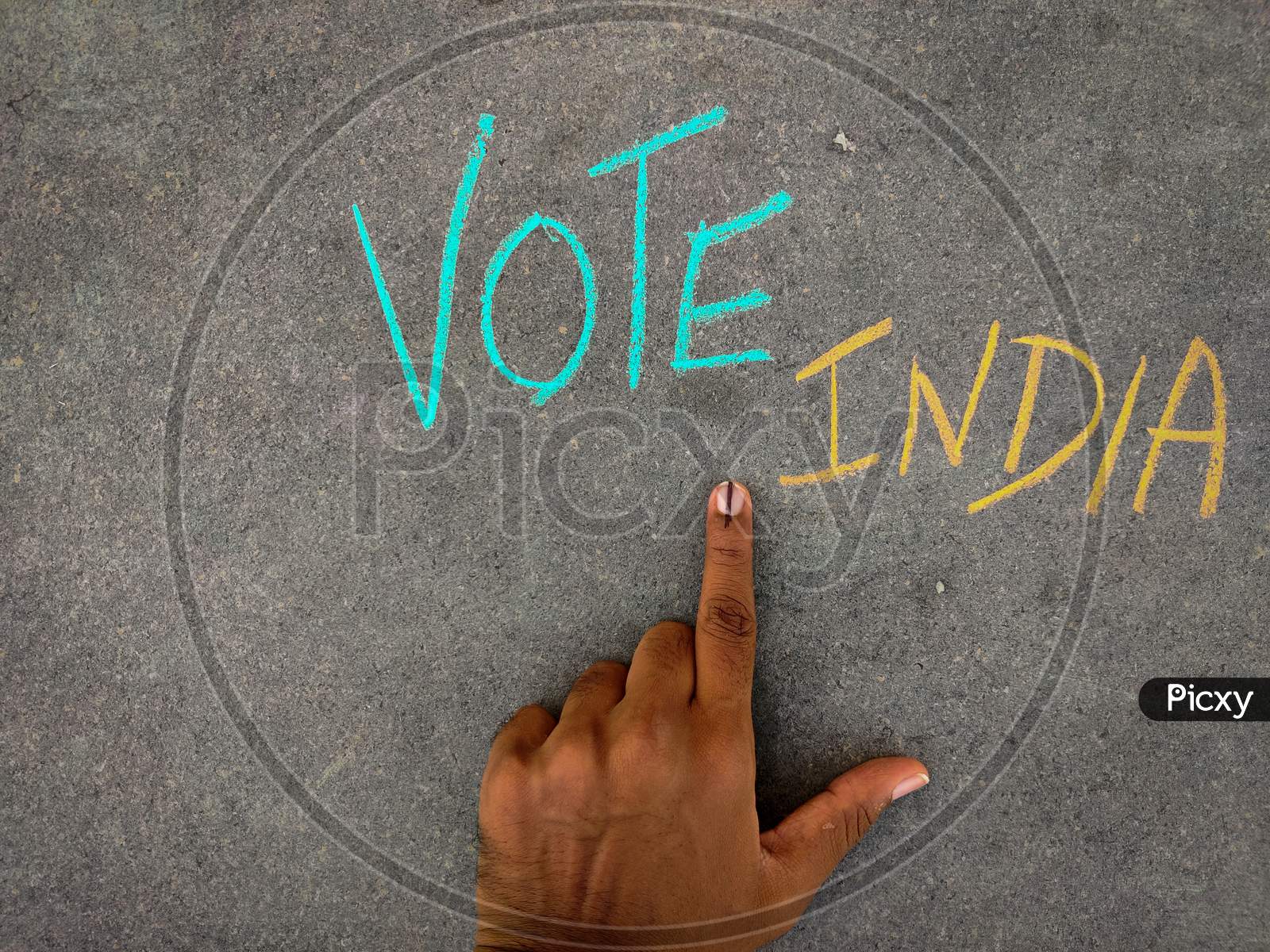 The Inscription Text On The Grey Board, Vote India Using Color Chalk Pieces And Male Hand With Voting Sign Or Inked.