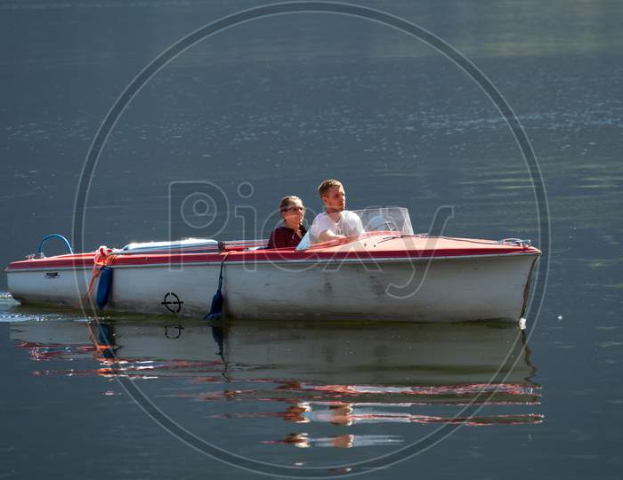 Two People In A Speedboat On Lake Hallstatt