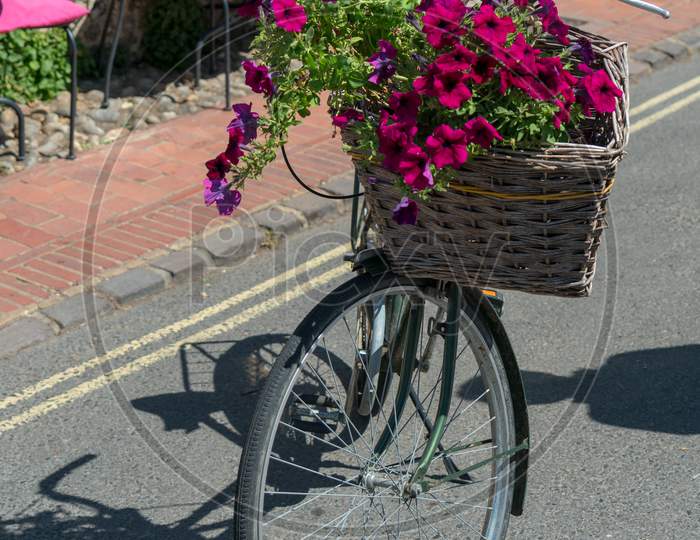 Alfriston, Sussex/Uk - July 23 : View Of An Old Bicycle With A Basket Of Flowers In Alfriston Sussex On July 23, 2018