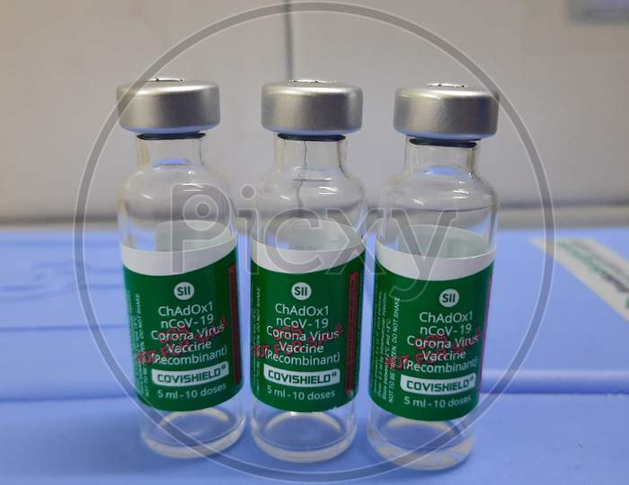 Three Covid 19 Covishield Vaccine Vials Placed Over A Vaccine Carrier.