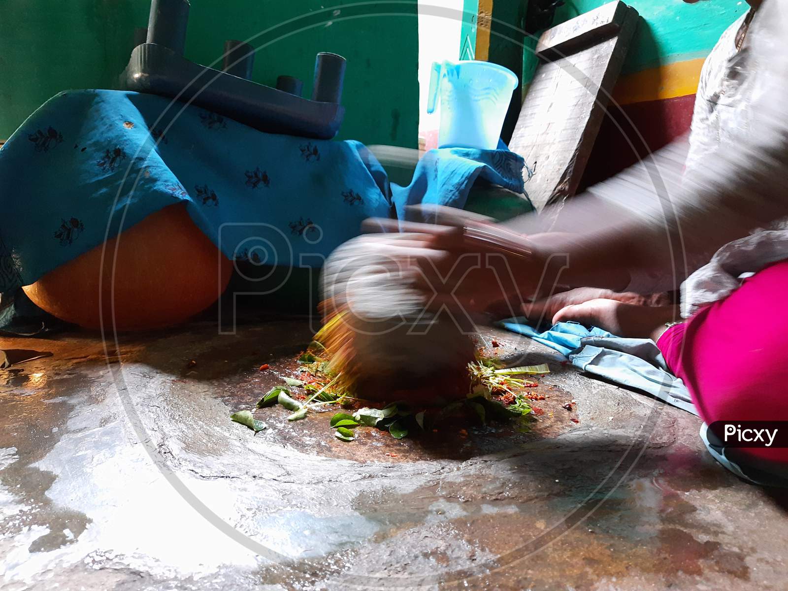 Image of Closeup Indian Girl grinding Masala or Chutney in a traditional  way using grinding stones-UZ373618-Picxy