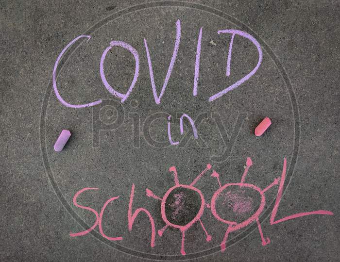 The Inscription Text On The Grey Board, Covid In School With Hand Drawn Coronavirus. Using Color Chalk Pieces.