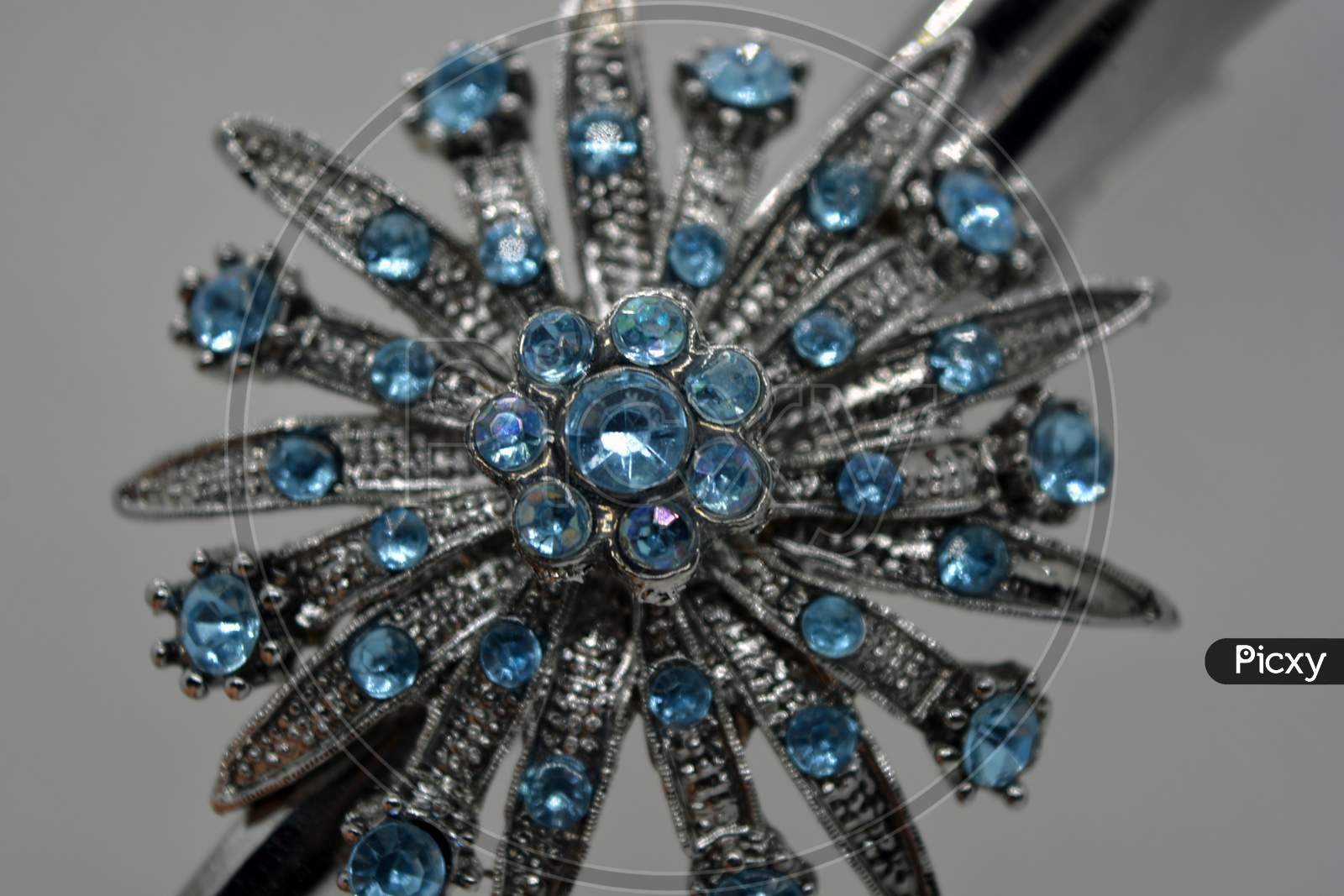 A large beautiful metal decoration, hairpin with blue small and interesting stones.