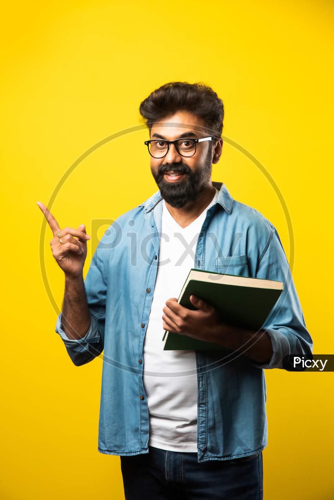Indian Asian Bearded Man Reading Or Holding Book Against Yellow Studio Background