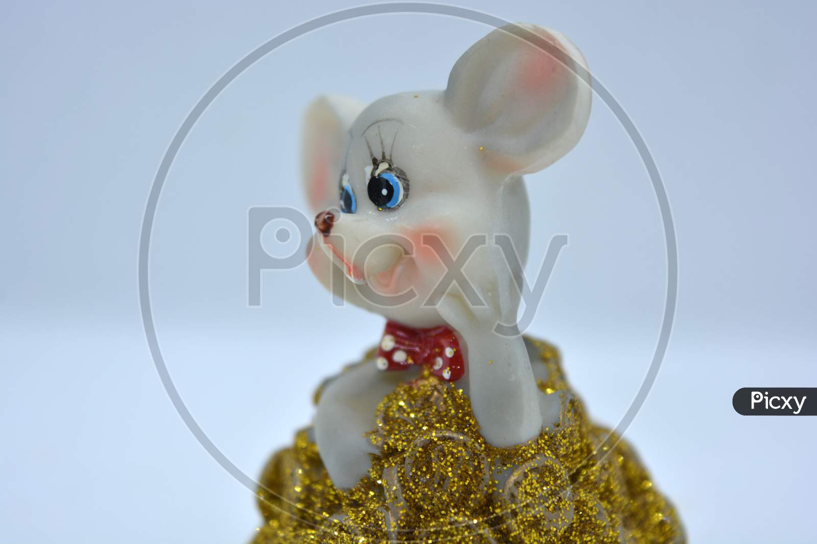 Ceramic statuette of a cute gray mouse with large ears that stands in a pile of brassing gold coins.