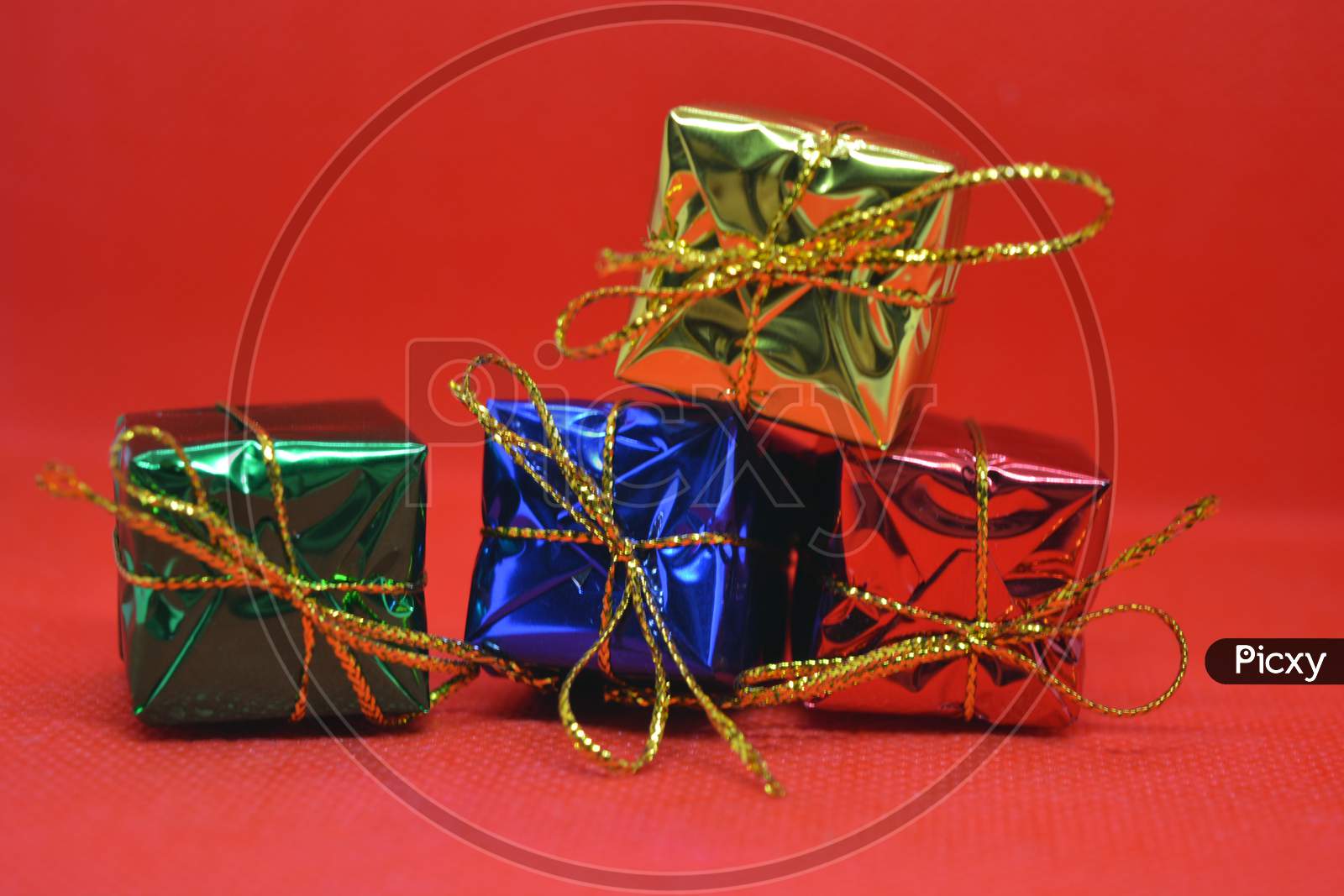 Bright attractive pile of gifts of different color located on a red background.