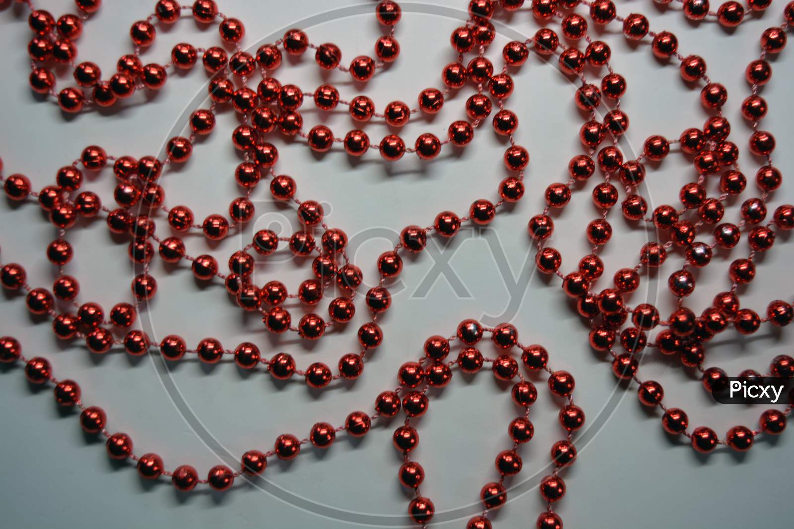 Beautiful red minor Christmas beads for decorating Christmas tree arranged on a white background.