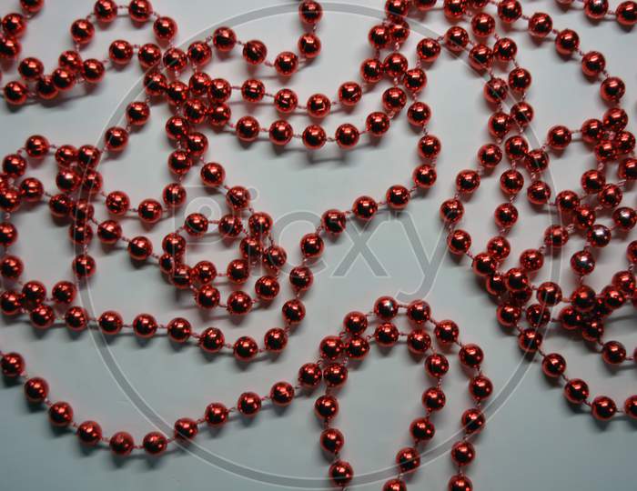 Beautiful red minor Christmas beads for decorating Christmas tree arranged on a white background.