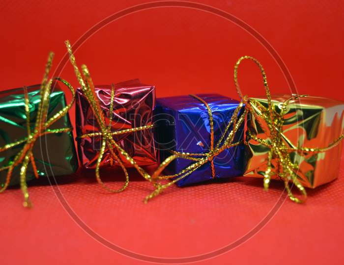 Bright attractive pile of gifts of different color located on a red background.