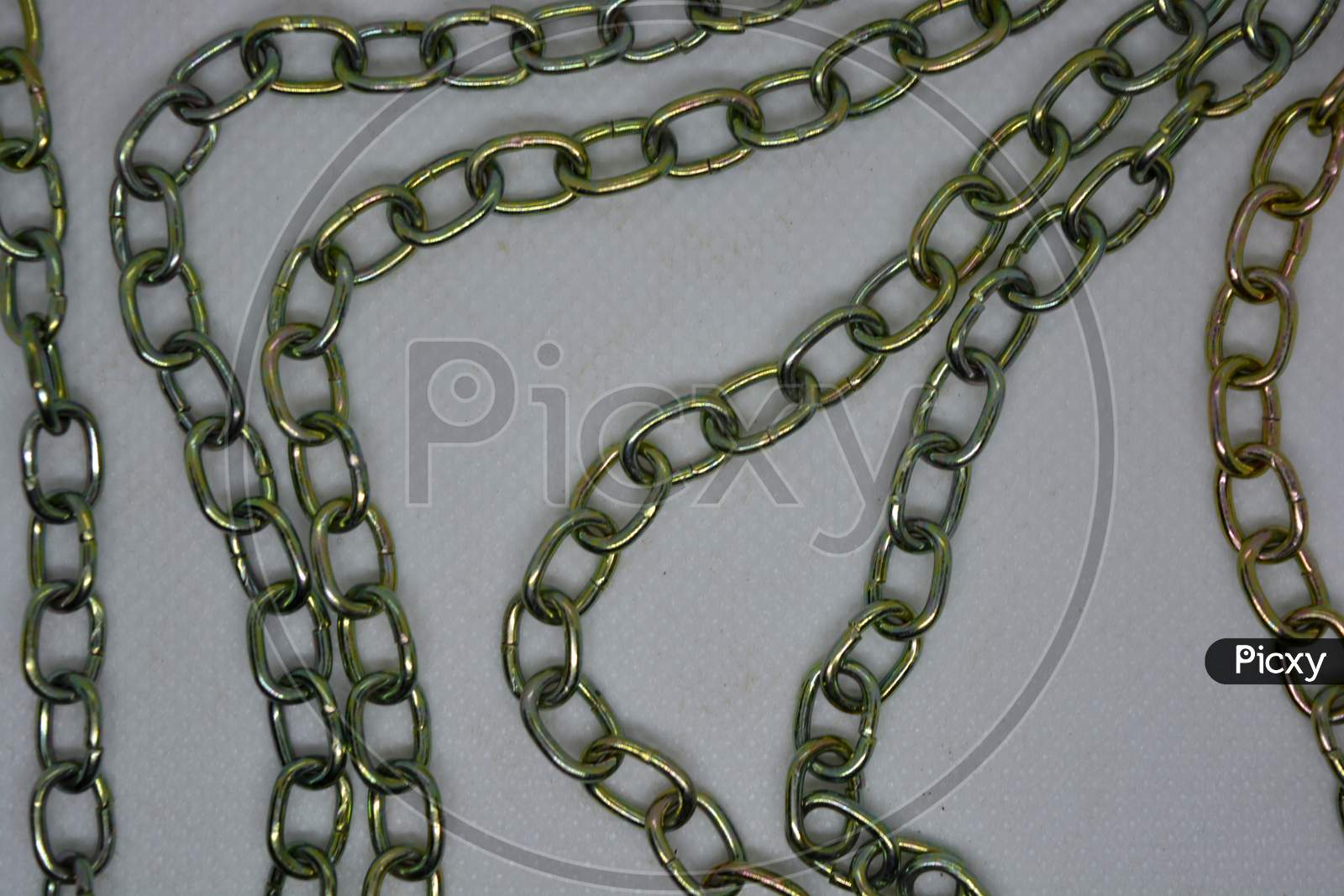 Unusual bright metal chains with overflows located chaotic way on a white background.