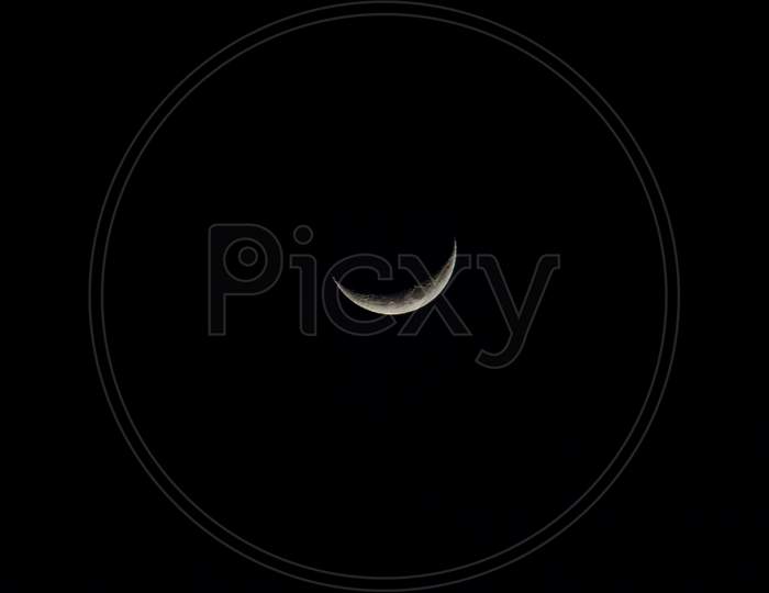 Moon Reflecting Sunlight In A Crescent Quarter. Black Night Sky Background. Satellite Of The Earth