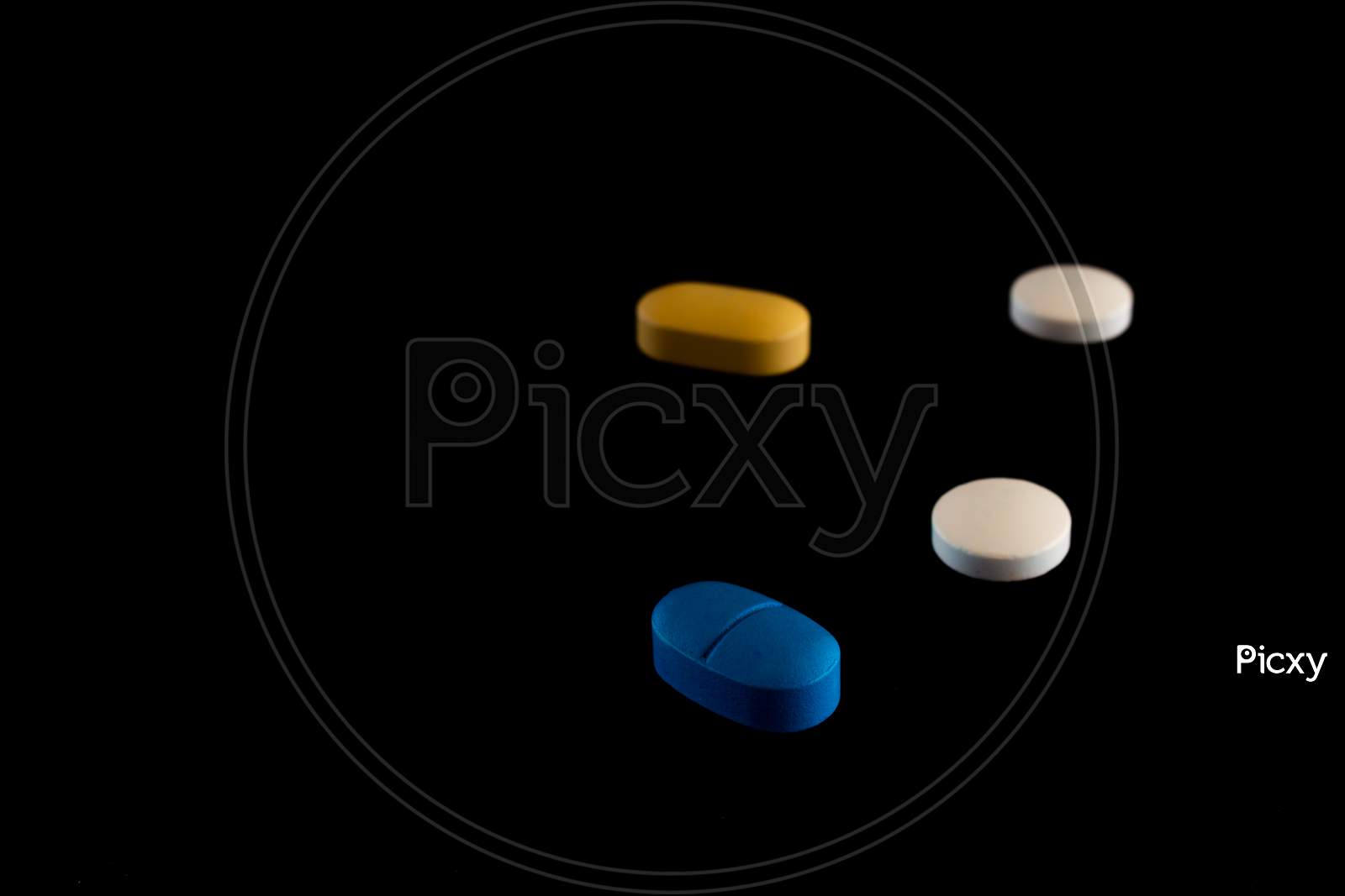 Pills Of Colors On A Neutral Black Background. Selective Focus Of Legal Drugs
