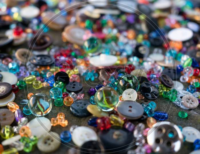 A Group Of Randomly Scattered Beads, Buttons And Marbles