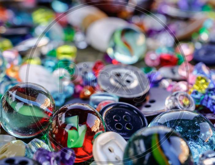 A Group Of Randomly Scattered Beads, Buttons And Marbles