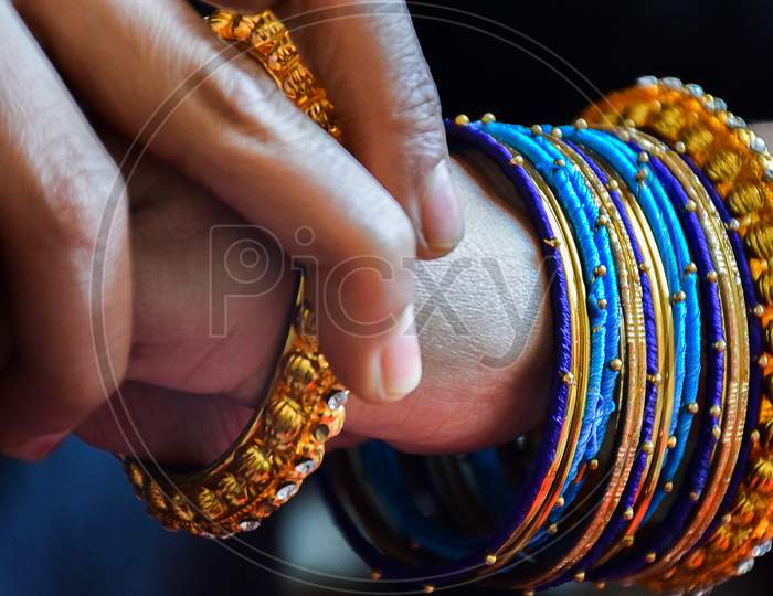 Stock Photo Of A Hand Of Indian Women Wearing Colorful Bangles With Gold Indian Design Bracelet, Picture Captured At The Time Of Indian Wedding Season At Bangalore Karnataka India.
