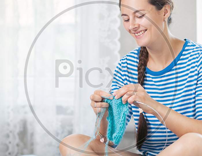 Young Woman Knits A Woolen