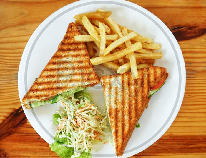 Grilled sandwich with fries and salad