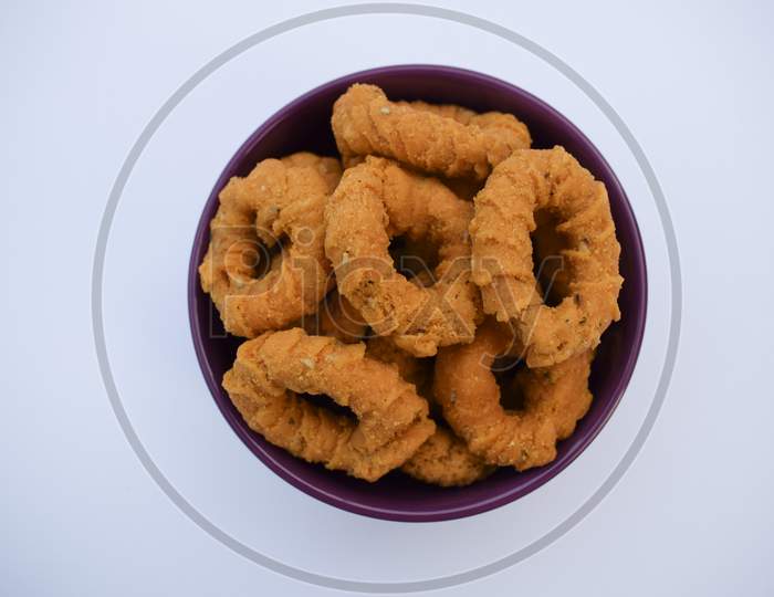 Top View Of South Indian Traditional Snack Item, Evening Tea Time Item Chegodilu Or Ring Murukku Isolated On White Background In White Plate Served During Festival
