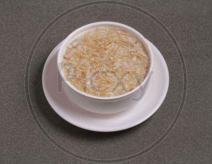 Khir Or Kheer Payasam Also Known As Sheer Khurma Seviyan Consumed Mainly On Eid Or Any Other Festival In India / Asia. Served With Dried Fruit Schnitzel In A Bowl On A Colorful / Wooden Background.
