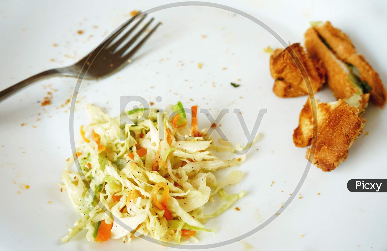 leftover food and fork on white plate
